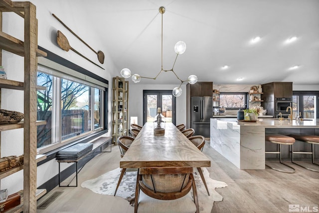 dining area featuring plenty of natural light, light hardwood / wood-style floors, and french doors