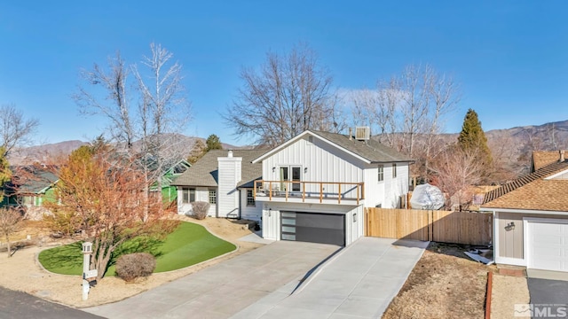 view of front of home with a mountain view, central AC unit, and a balcony