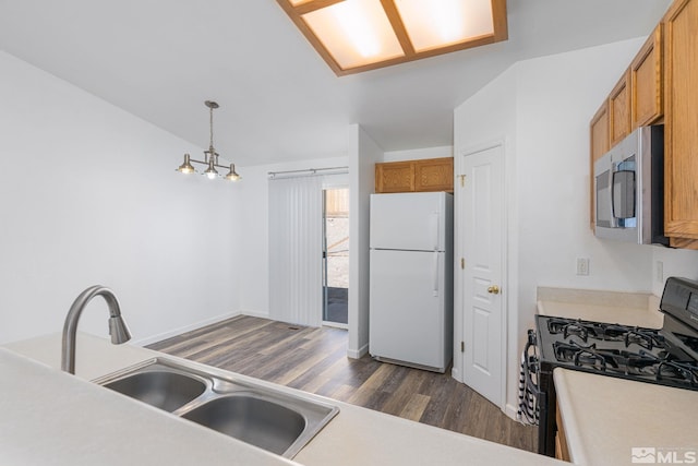 kitchen with pendant lighting, sink, black gas range, dark hardwood / wood-style flooring, and white fridge