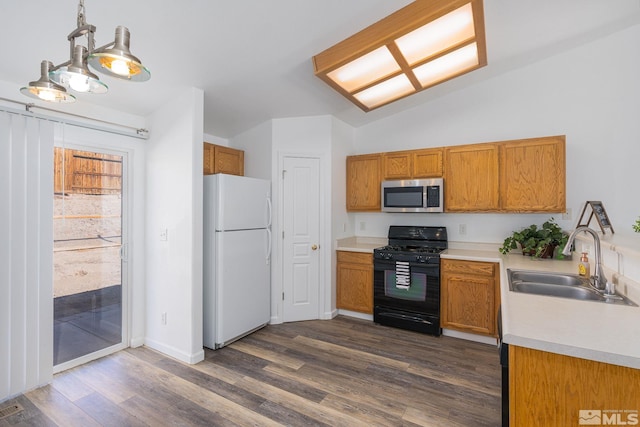 kitchen with sink, dark wood-type flooring, black gas range, hanging light fixtures, and white refrigerator