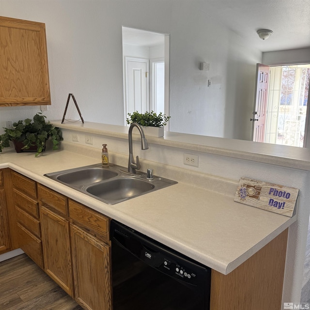 kitchen with dark wood-type flooring, dishwasher, sink, and kitchen peninsula