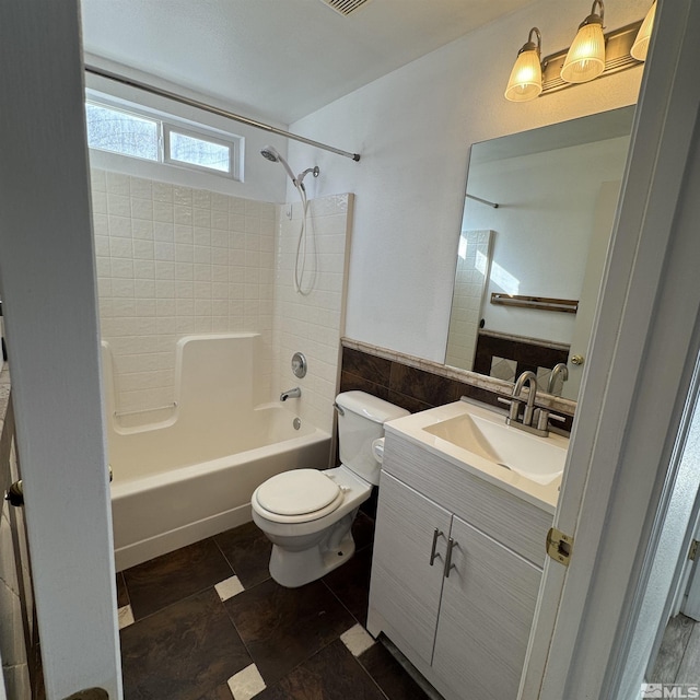 full bathroom featuring toilet, tile walls, vanity, shower / bath combination, and tile patterned flooring