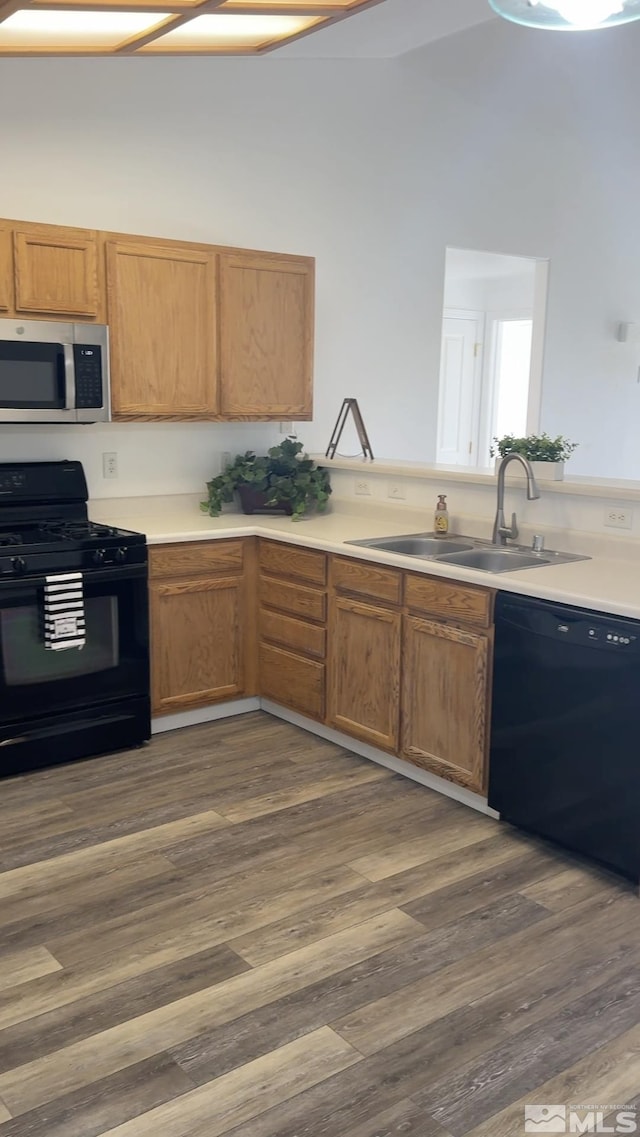 kitchen featuring sink, black appliances, and dark hardwood / wood-style floors