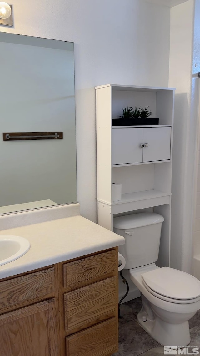 bathroom featuring vanity, a bath, and toilet