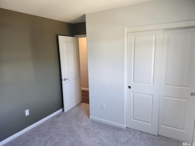 unfurnished bedroom featuring light colored carpet and a closet