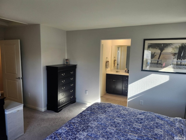 bedroom featuring light carpet, sink, and ensuite bathroom