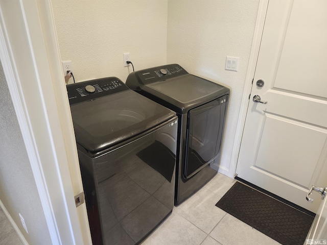 laundry room featuring light tile patterned flooring and washer and clothes dryer