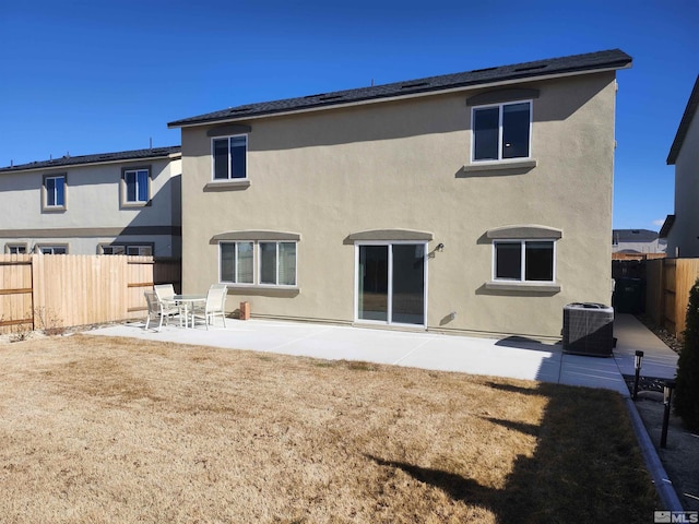 rear view of house featuring a yard, central air condition unit, and a patio area