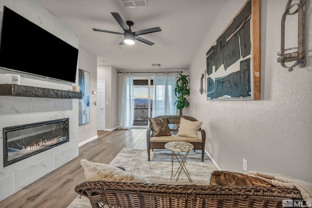 living room featuring hardwood / wood-style floors, a fireplace, and ceiling fan