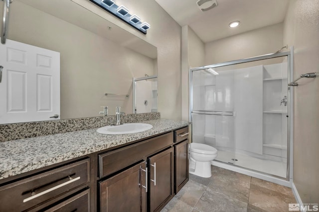 bathroom featuring a shower with door, vanity, and toilet