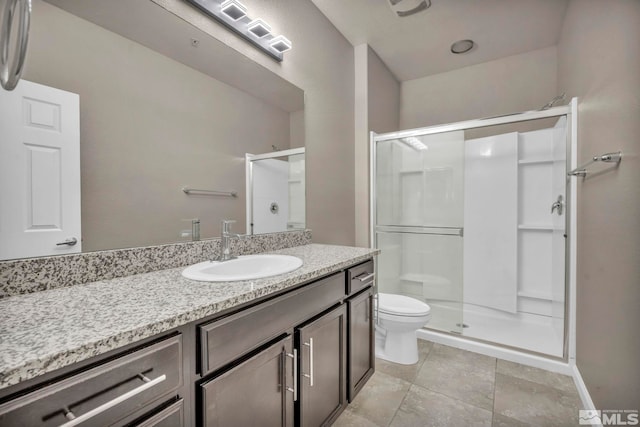 bathroom with vanity, a shower with shower door, and toilet