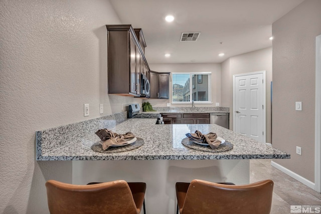 kitchen featuring a breakfast bar, stainless steel appliances, and kitchen peninsula