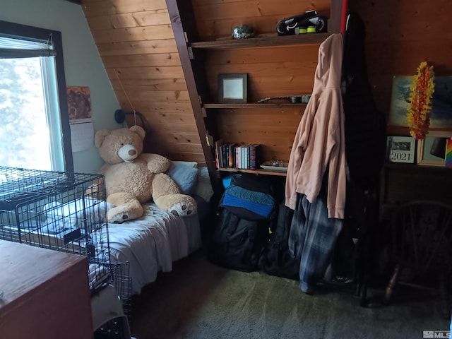 carpeted bedroom featuring wood walls