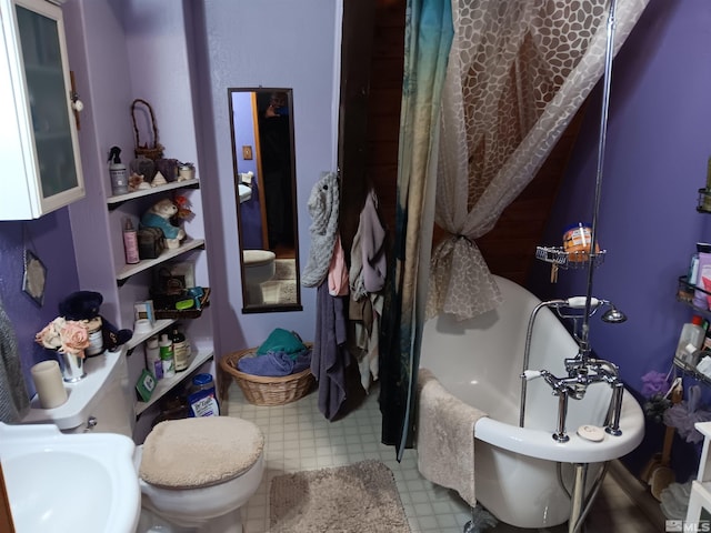 bathroom featuring a bath, sink, and toilet