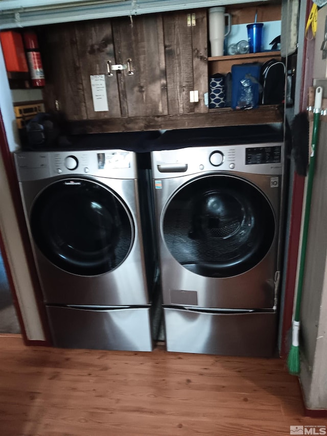 washroom with hardwood / wood-style floors and washer and dryer