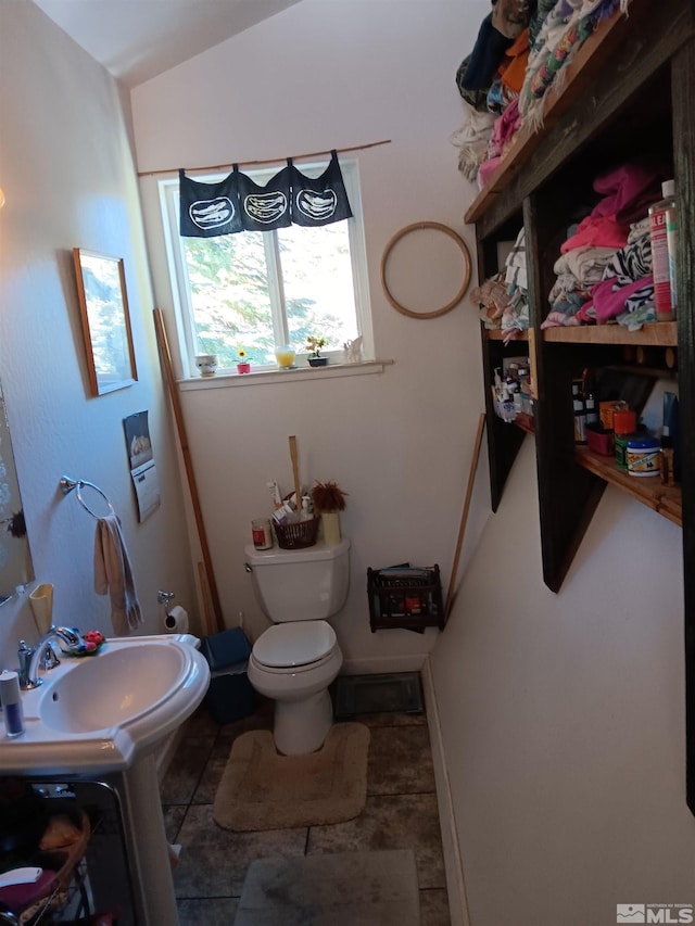 bathroom featuring vanity, vaulted ceiling, and toilet