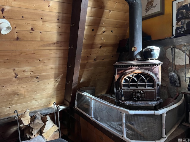 interior details featuring wooden walls and a wood stove