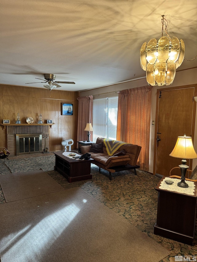 living room featuring ceiling fan, carpet flooring, a fireplace, and wood walls