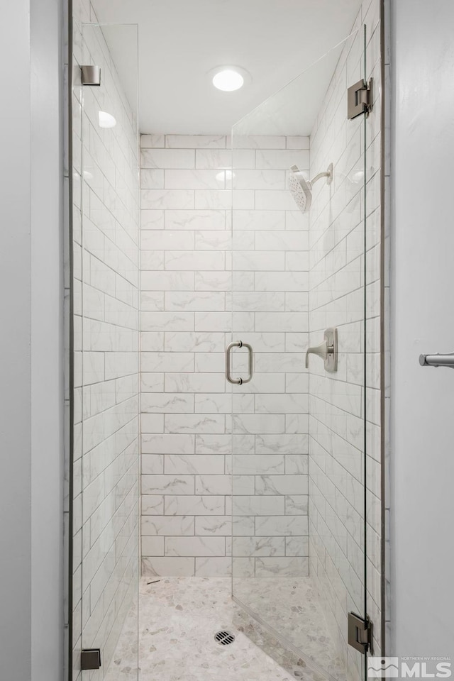 bathroom featuring a shower with door