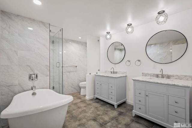 full bathroom with vanity, shower with separate bathtub, tile walls, and toilet