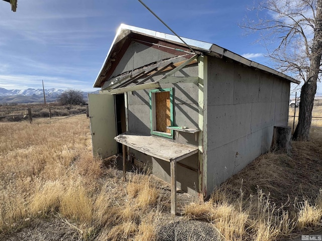 view of side of home featuring a mountain view and an outdoor structure