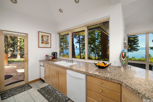 kitchen with lofted ceiling, light brown cabinetry, sink, light tile patterned floors, and white dishwasher