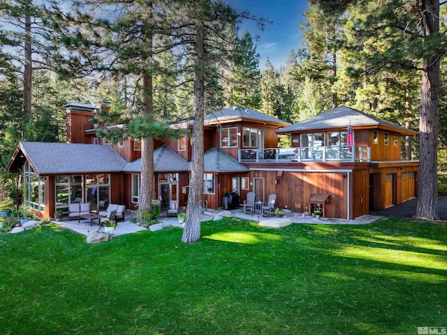 rear view of property featuring a patio and a lawn