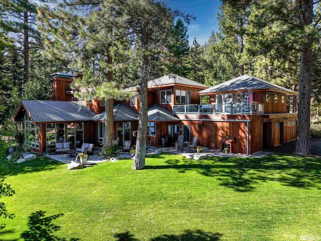 rear view of property with a lawn and a patio