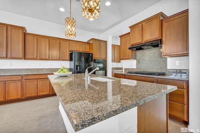 kitchen with sink, decorative light fixtures, a kitchen island with sink, and black appliances