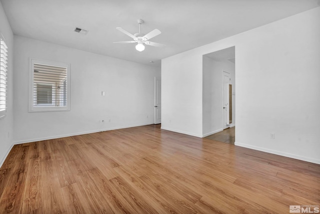 empty room with ceiling fan and light hardwood / wood-style flooring