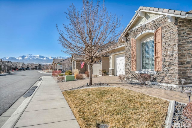 exterior space featuring a garage, a yard, and a mountain view