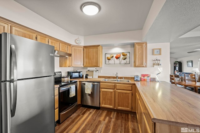 kitchen with appliances with stainless steel finishes, dark hardwood / wood-style floors, sink, kitchen peninsula, and a textured ceiling