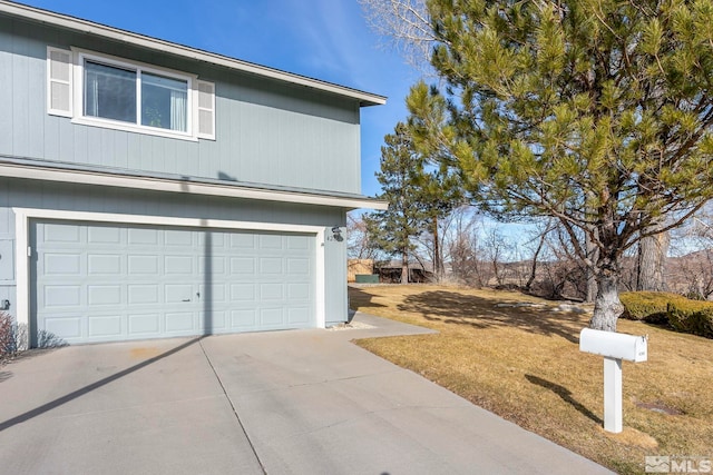 view of side of home featuring a garage and a lawn