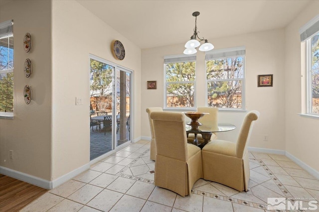 tiled dining room featuring an inviting chandelier