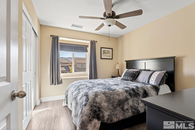 bedroom featuring hardwood / wood-style flooring, ceiling fan, and a closet