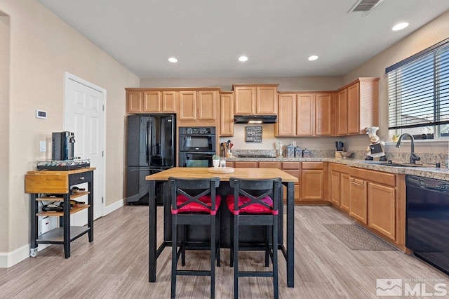 kitchen featuring light brown cabinets, sink, light hardwood / wood-style flooring, and black appliances