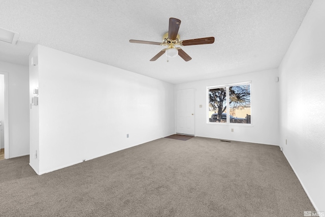 carpeted spare room with ceiling fan and a textured ceiling