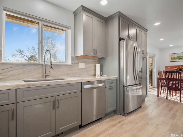 kitchen featuring appliances with stainless steel finishes, sink, and gray cabinetry