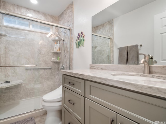 bathroom featuring vanity, toilet, and an enclosed shower