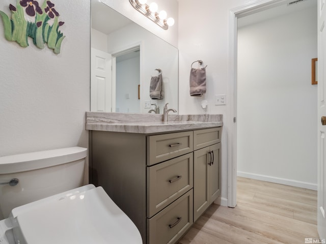 bathroom featuring vanity, toilet, and hardwood / wood-style floors