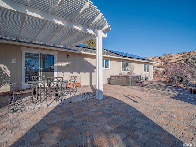 view of patio / terrace featuring a hot tub, a pergola, and a mountain view