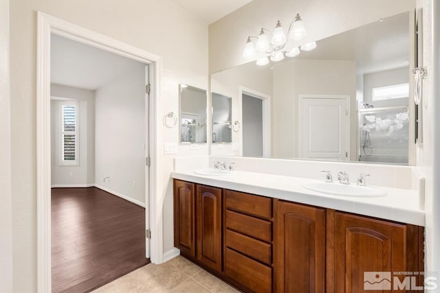 bathroom featuring tile patterned flooring, vanity, and an enclosed shower