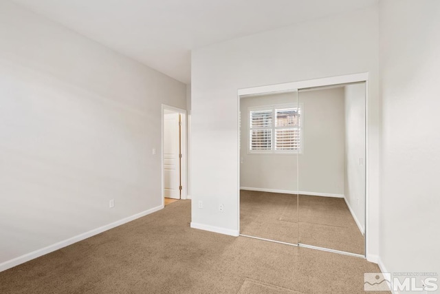 unfurnished bedroom with carpet and a closet