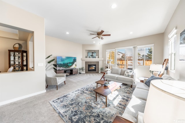 living room with ceiling fan, a fireplace, and carpet