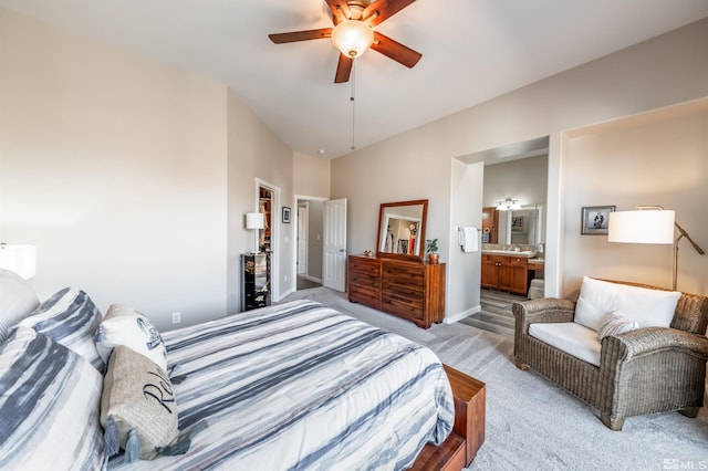 bedroom with connected bathroom, light colored carpet, and ceiling fan