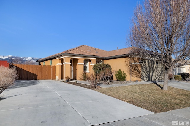 view of front of house with a mountain view and a front yard