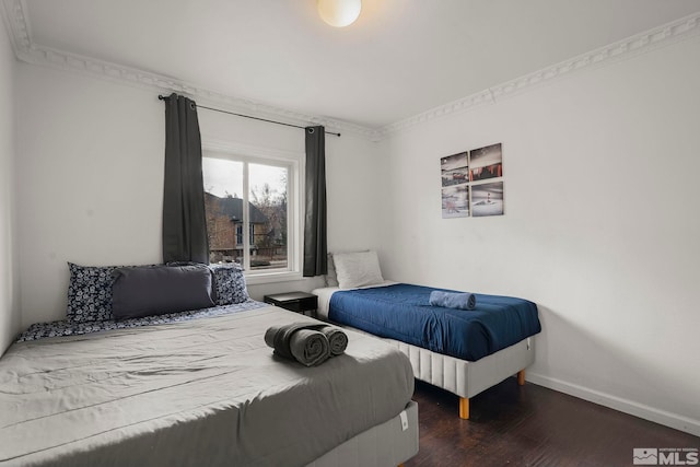 bedroom with ornamental molding and dark hardwood / wood-style floors