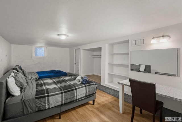 bedroom featuring hardwood / wood-style floors and a closet