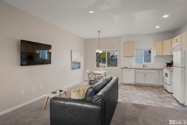living room with light colored carpet and sink