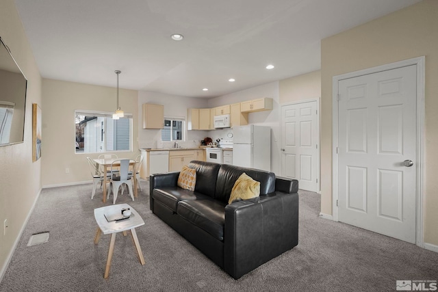 carpeted living room featuring sink